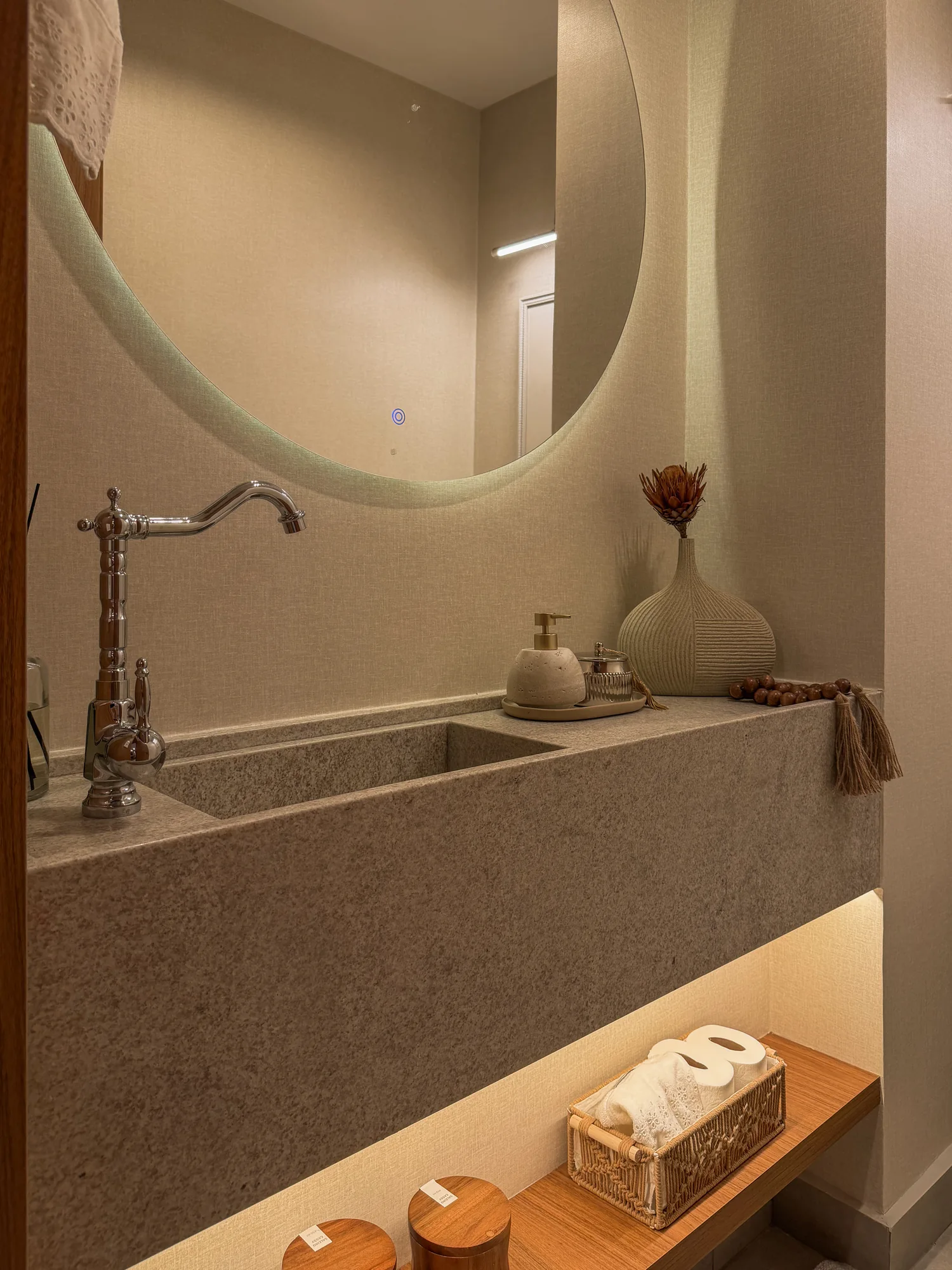 Bancada de pedra em lavabo com espelho iluminado